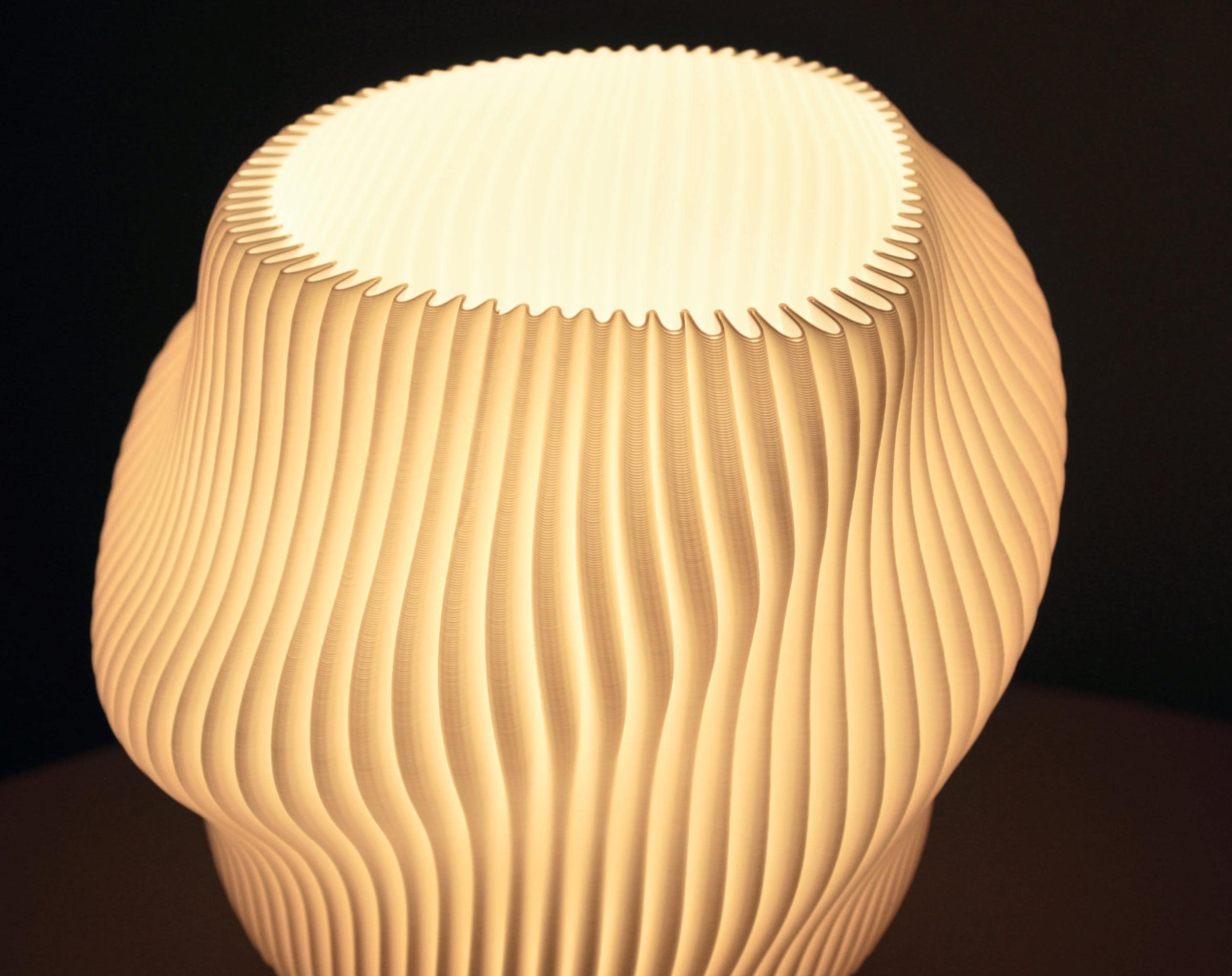 Close of an illuminated lamp showing the wavy and pleated shape
