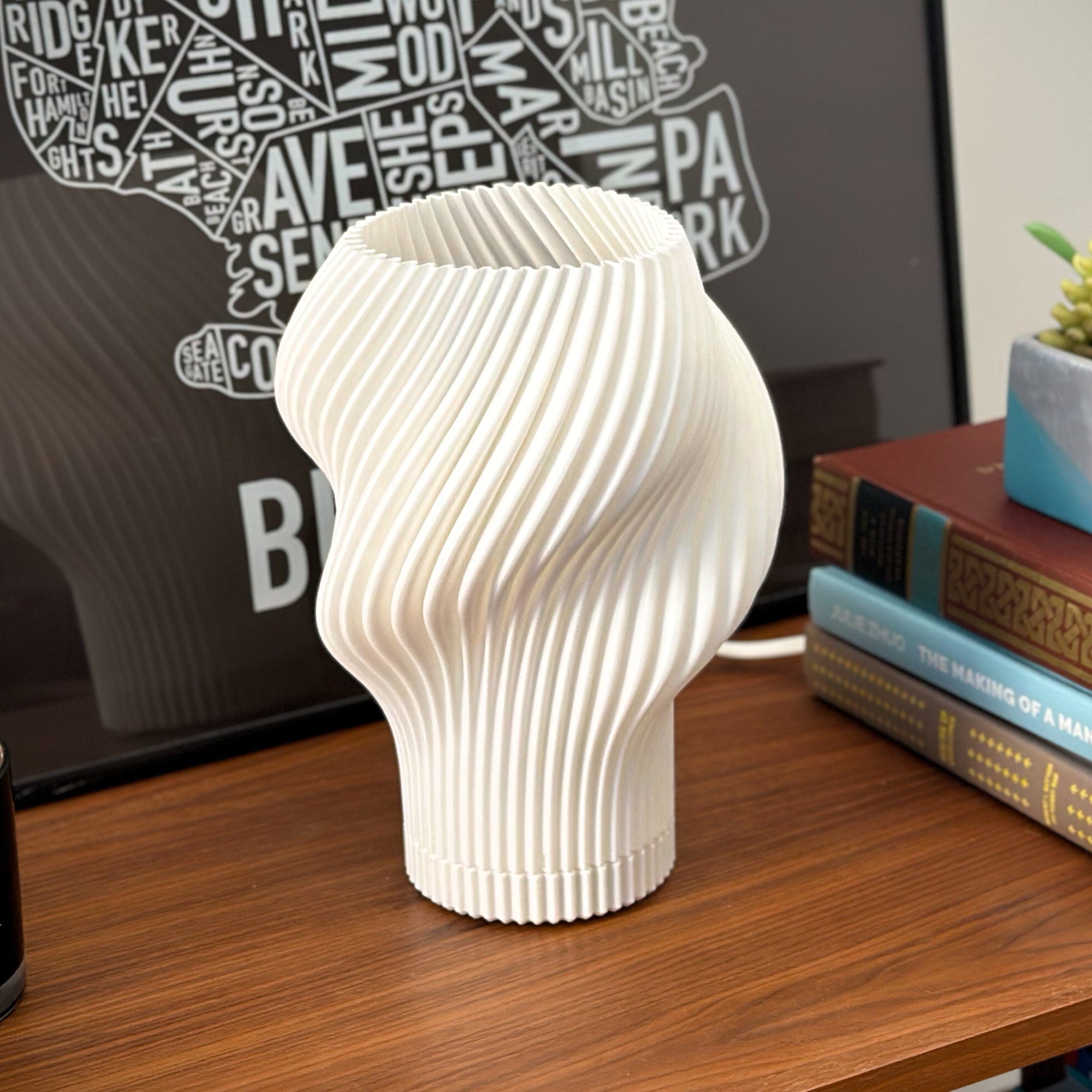 Floursh lamp unlit on a table, styled with a poster and stacked books