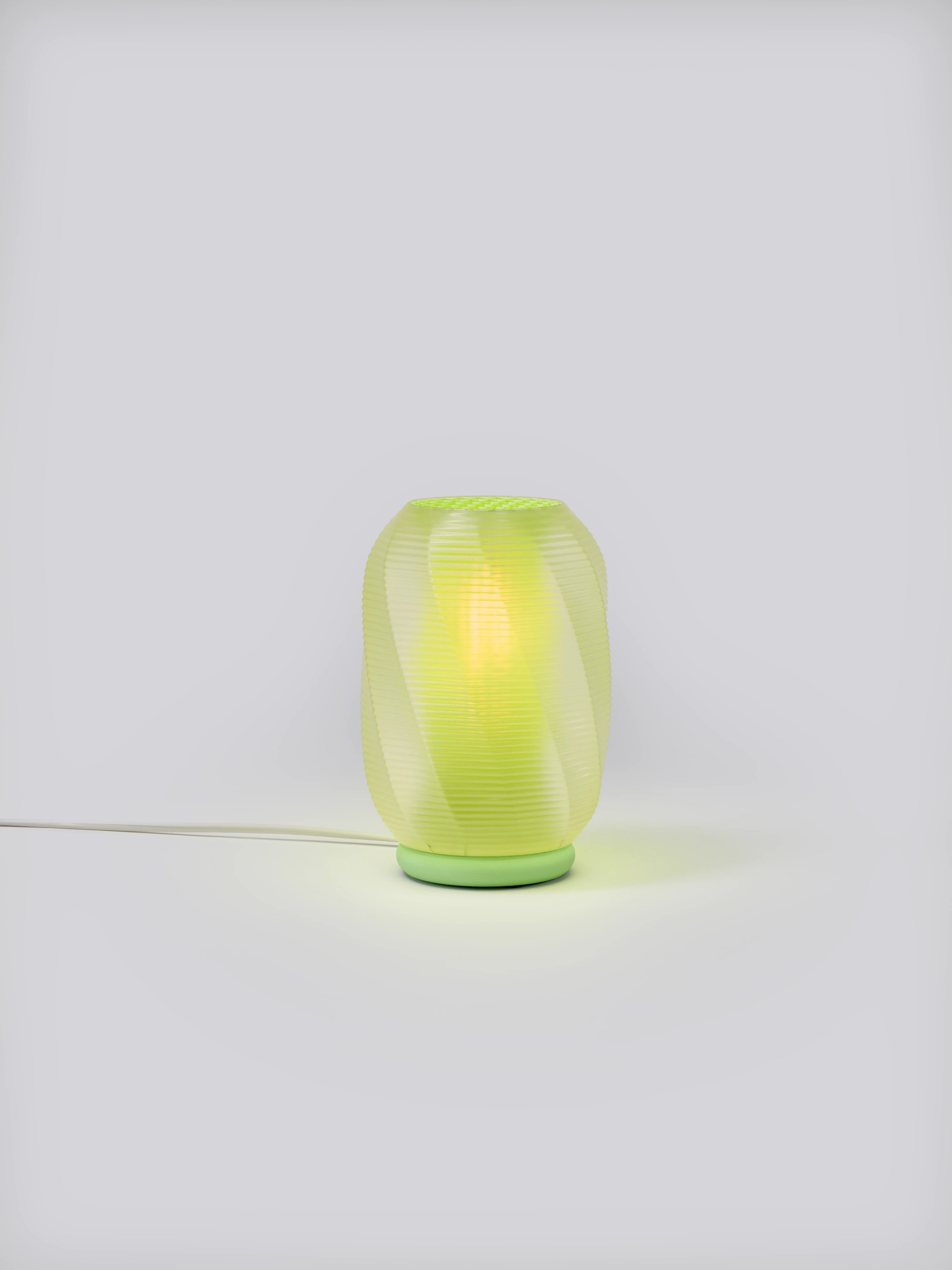 Mint green Nixie Lamp illuminated on a white studio background, showing colorful glow