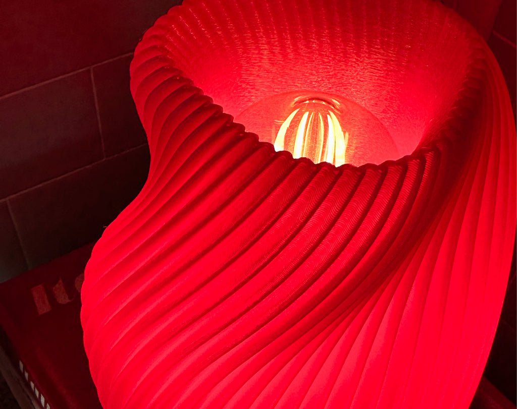 Pink Tama Lamp close-up with a warm white bulb.