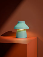 Light blue Zen Lamp illuminated on an orange block with high contrast lighting.