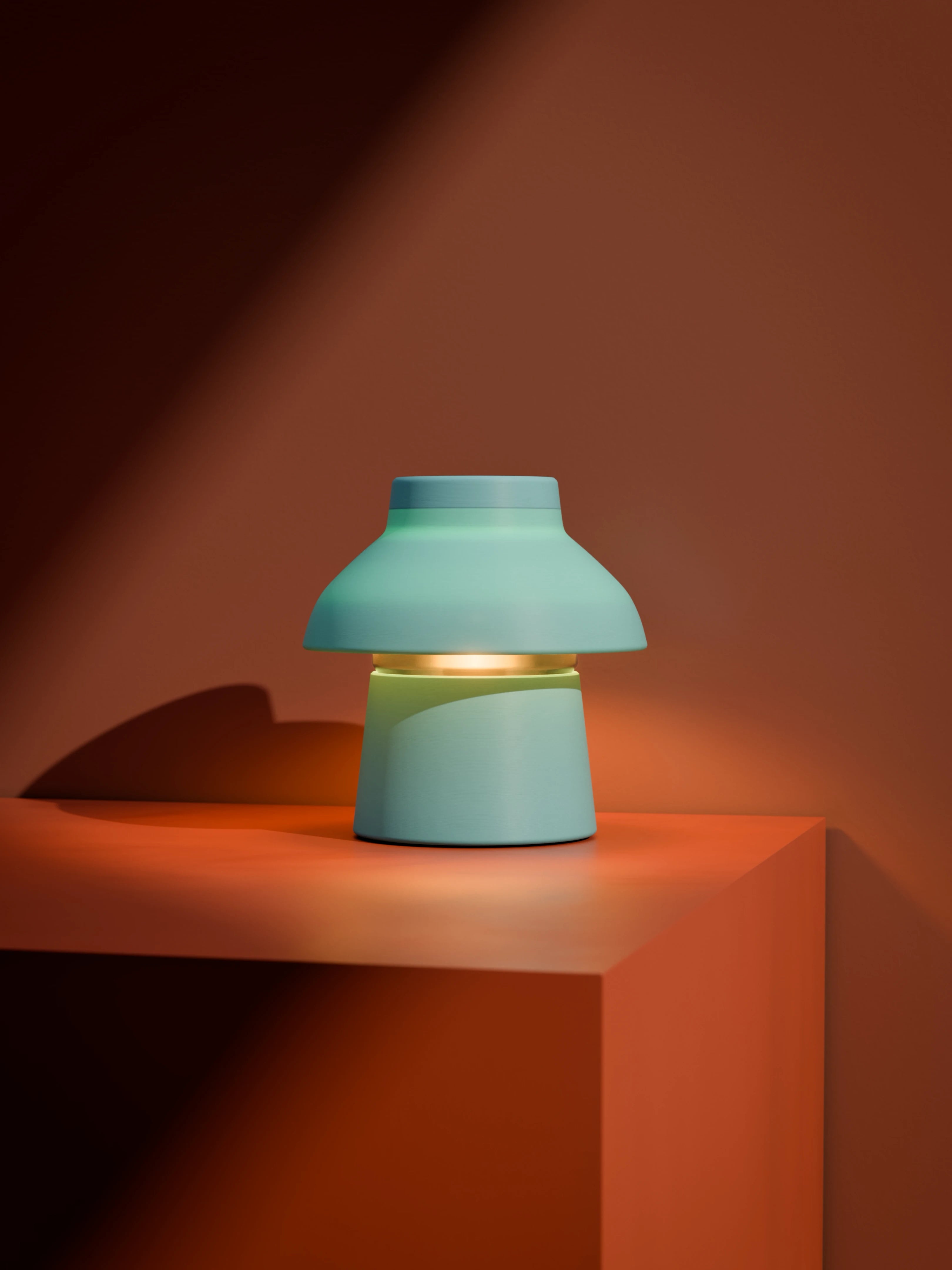 Light blue Zen Lamp illuminated on an orange block with high contrast lighting.